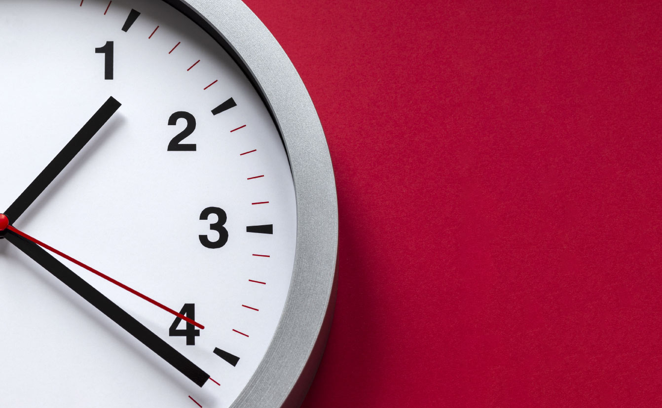 clock face on red background By stasknop via Adobe Stock