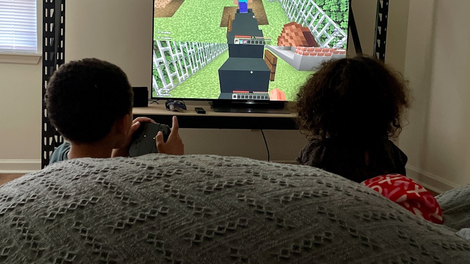 Aiden and Maddalyn playing Minecraft on a bean bag couch